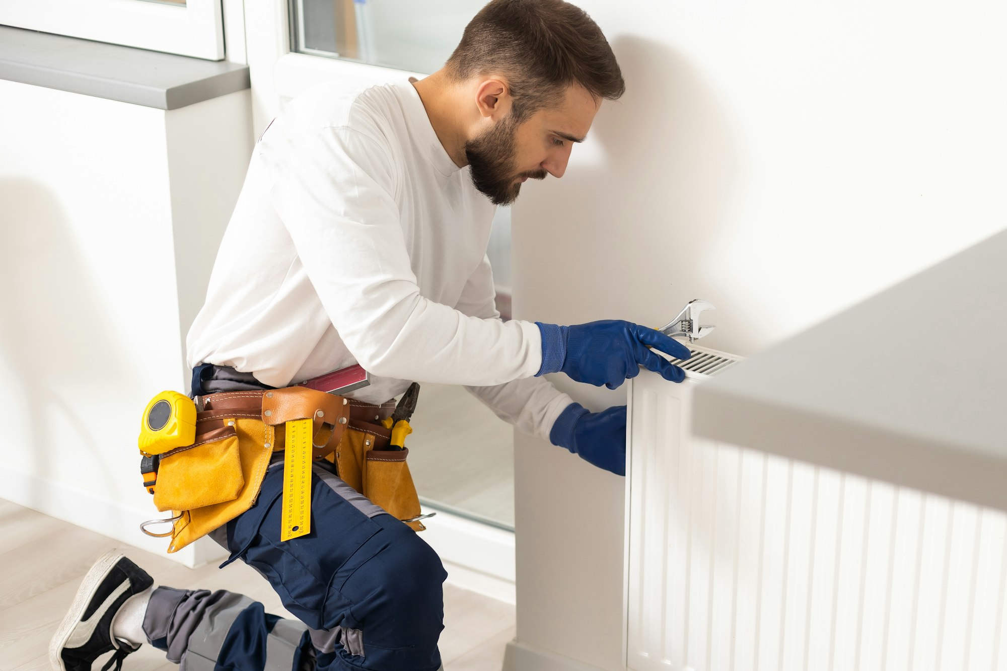 Repair heating radiator close-up. man repairing radiator with wrench. Removing air from the radiator