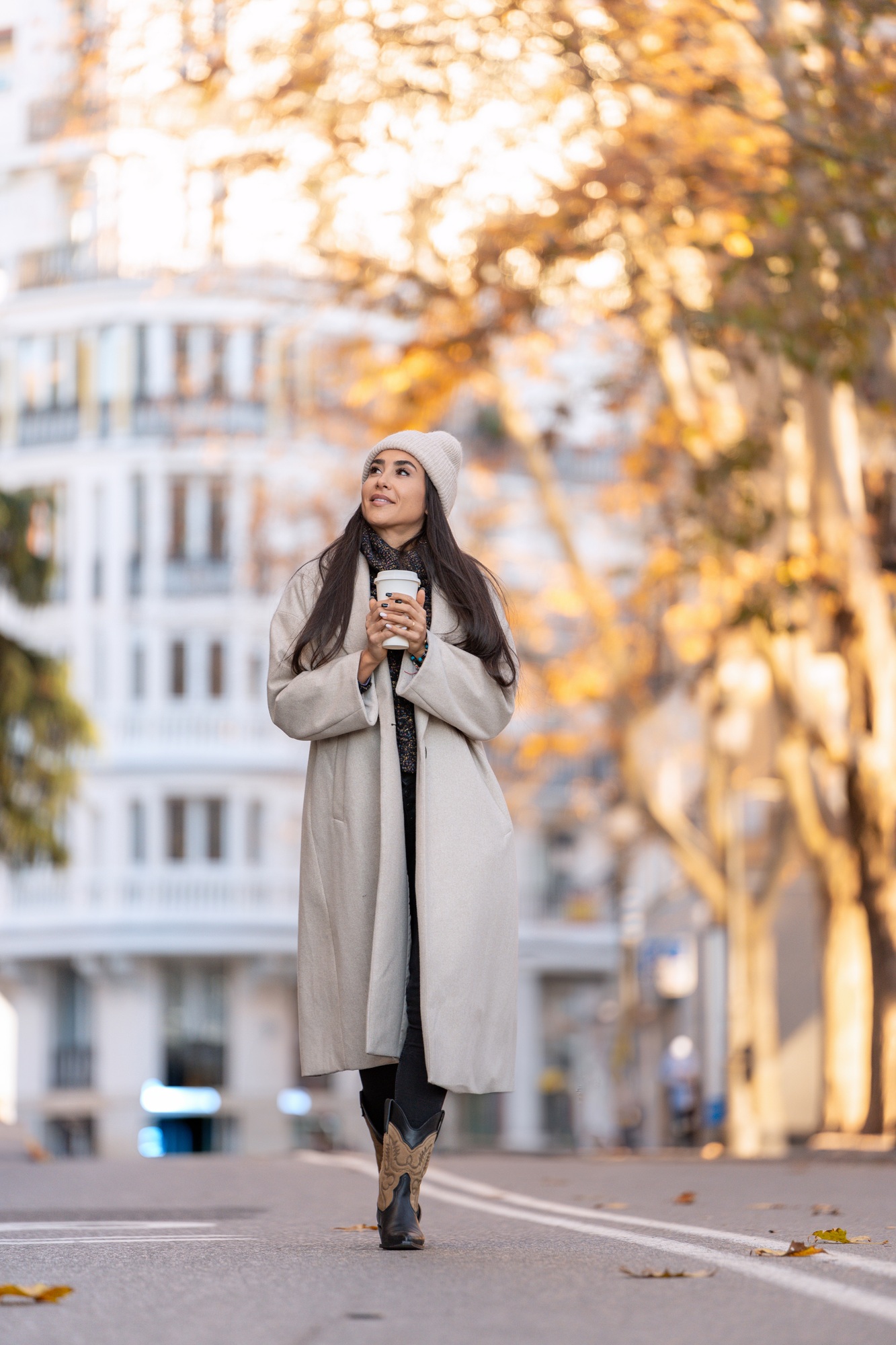 Stylish woman on city walk with coffee.